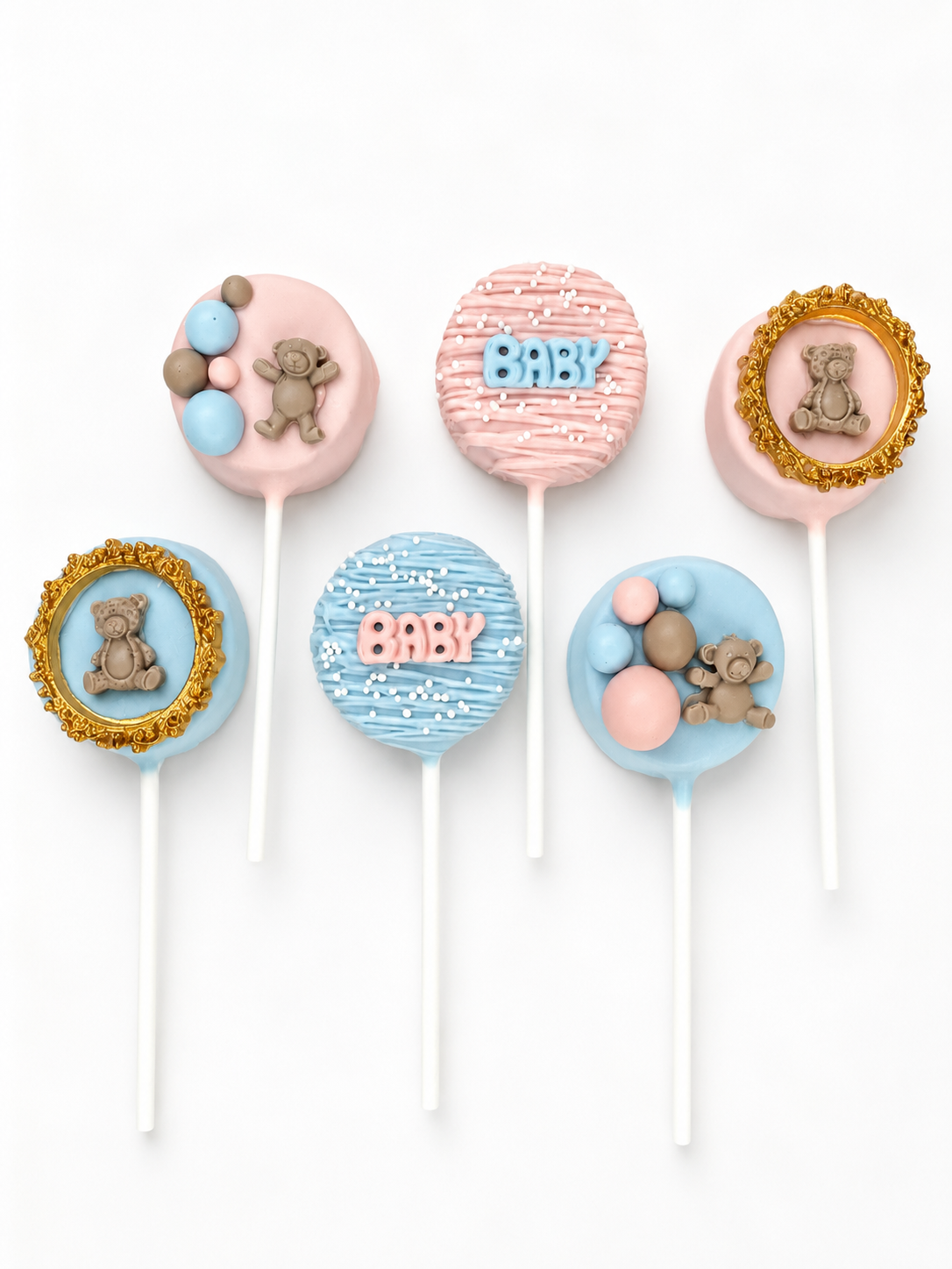 Baby shower cake pops in pink and blue with teddy bears, gold frames, and BABY lettering